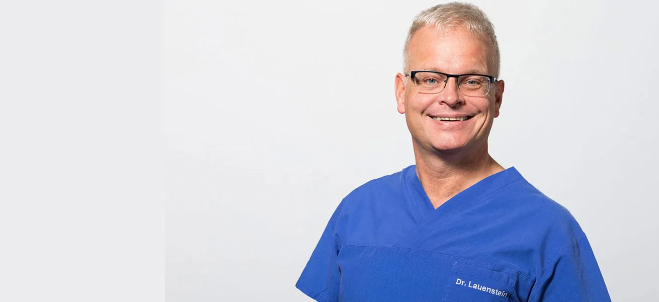 Dr. Ralf Lauenstein in blauer Praxiskleidung