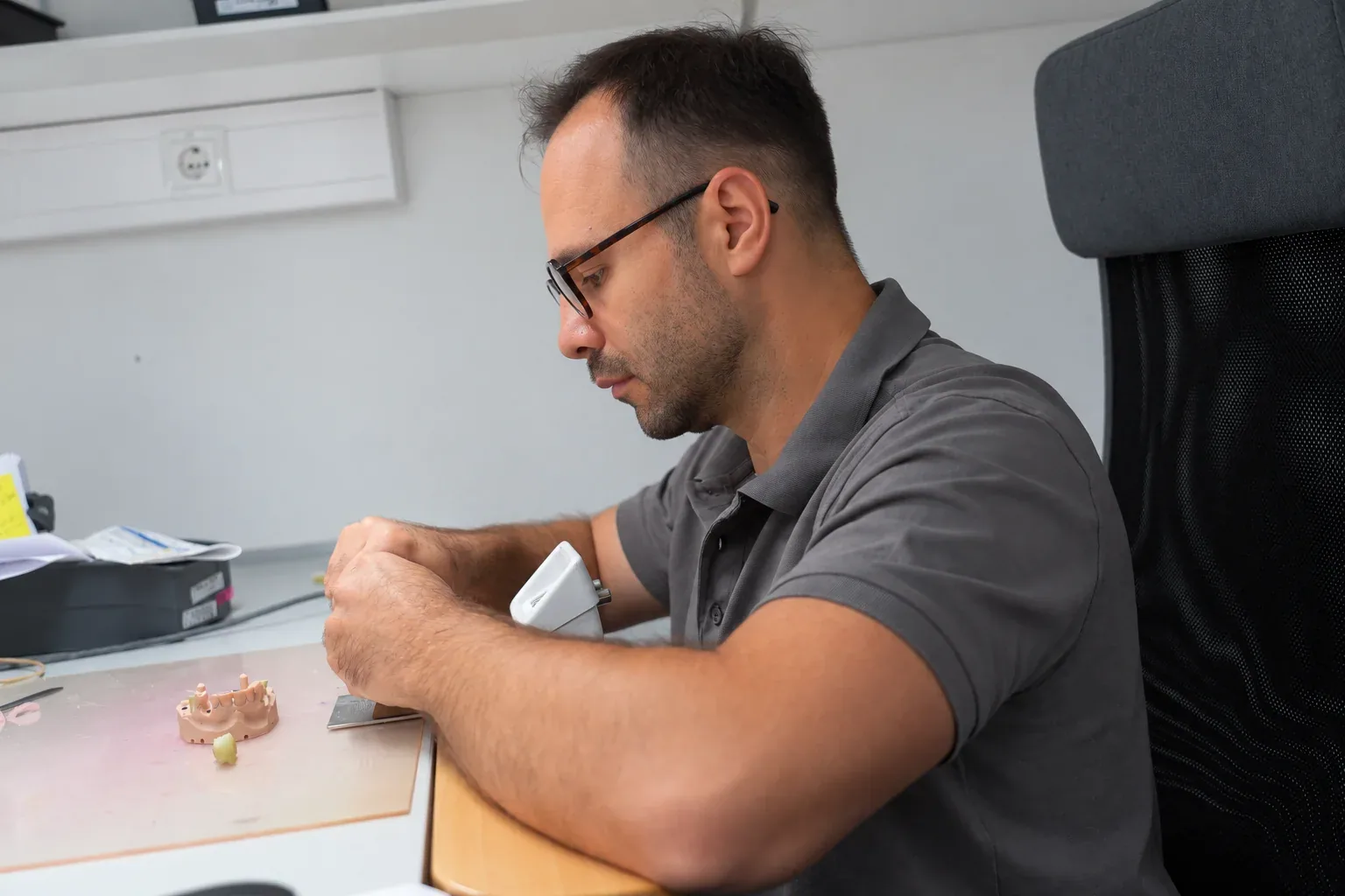 Zahntechniker bei der Arbeit am Modell im Praxislabor